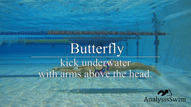 Butterfly kick underwater with arms above the head 